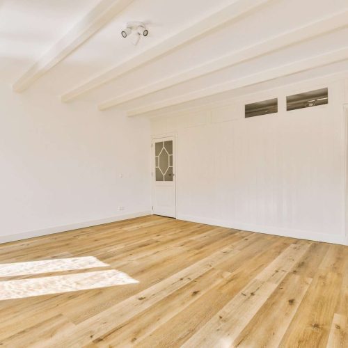 a living room with white walls and a wood floor