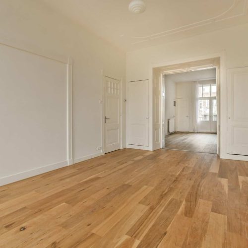 a living room with white walls and a wood floor